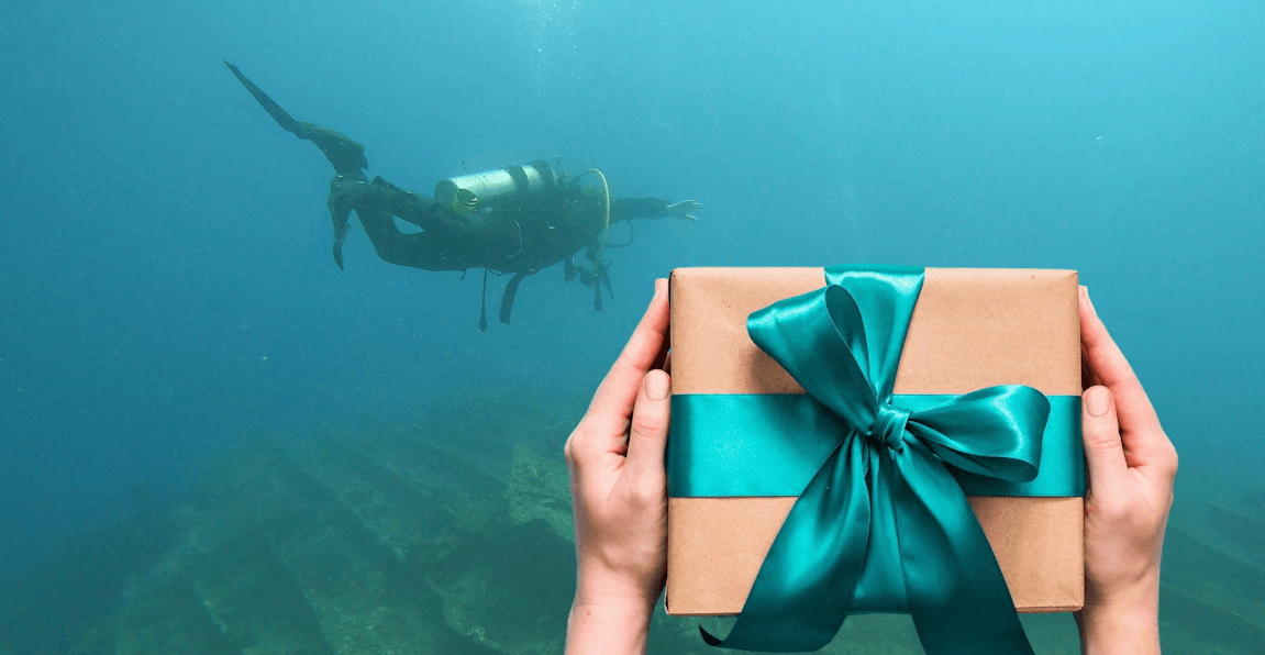 Braunes Geschenk mit Schleife neben einem schwebednen Taucher