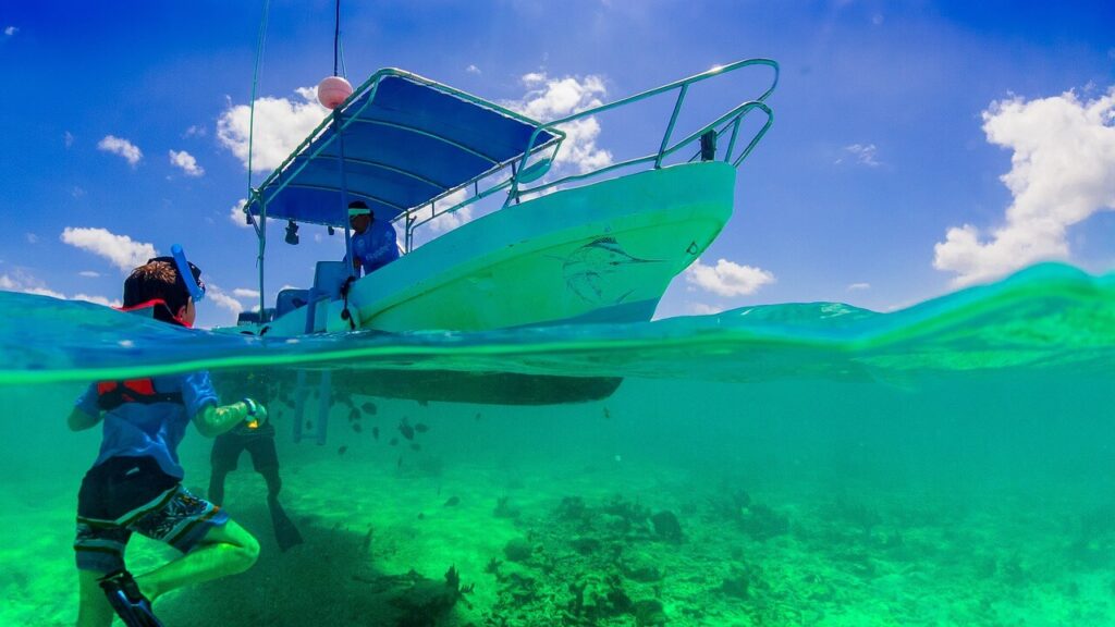 Junger Schnorchler vor einem Boot in einem der weltweit besten Schnorchelgebiete in Tulum Mexiko