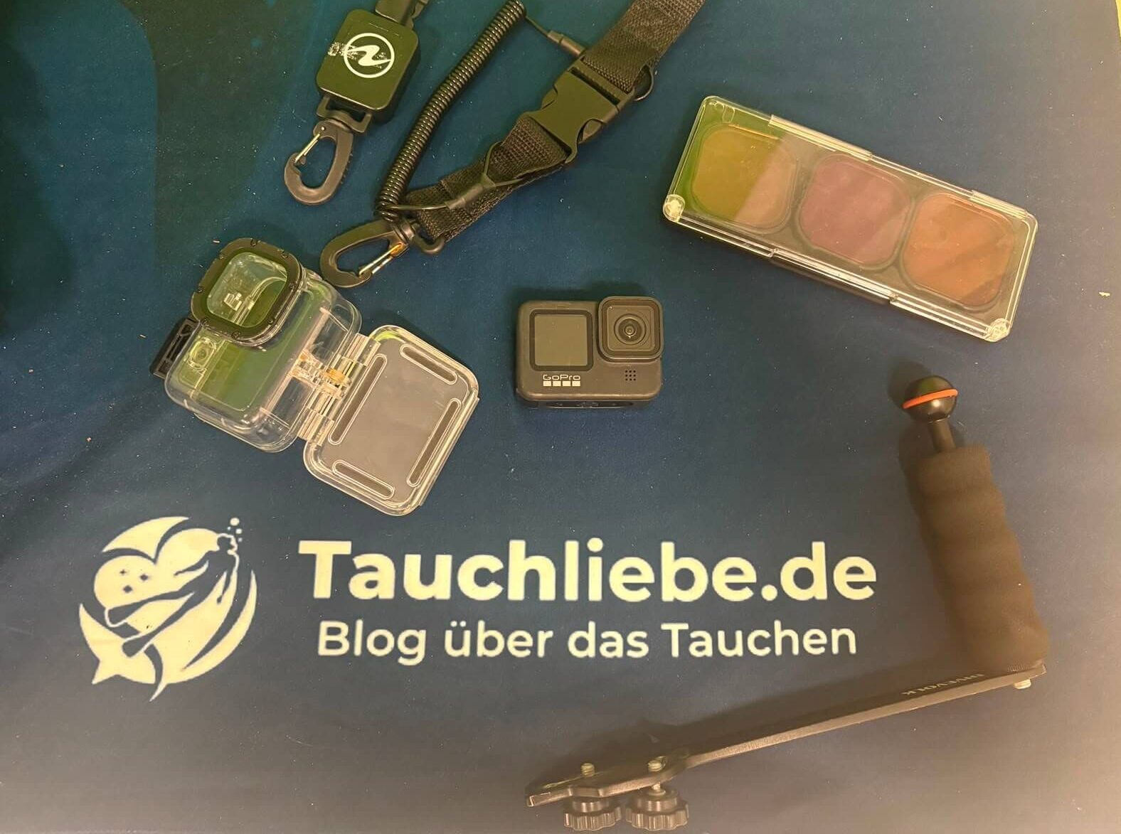 GoPro liegt neben Unterwasser Zubehör wie Halterung, Rotfilter und Befestigung auf Tauchliebe.de Handtuch