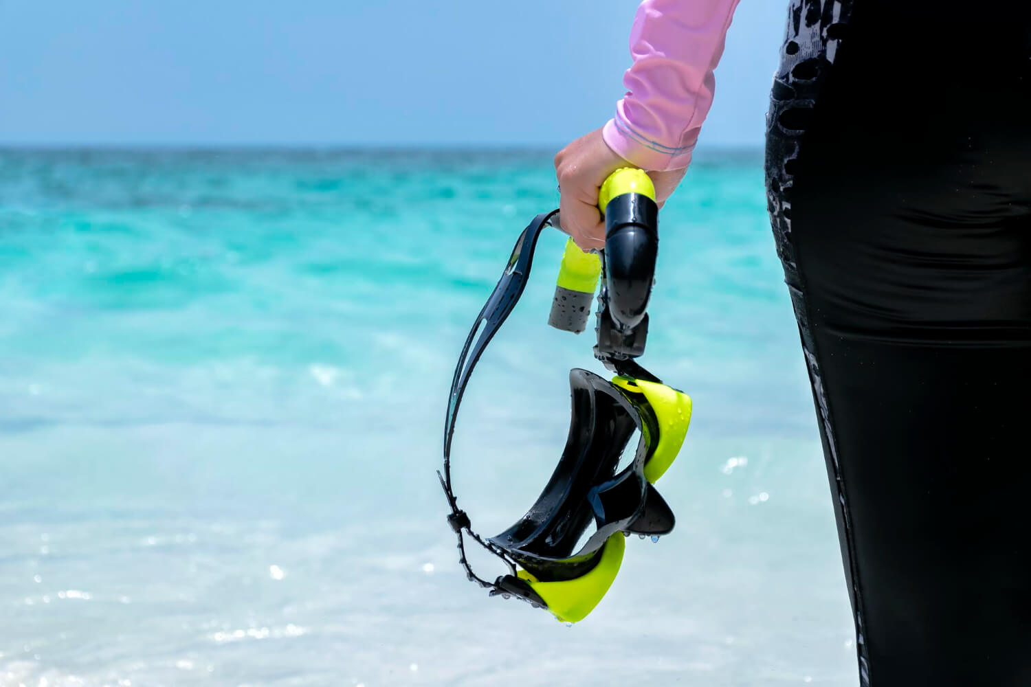 Frau hält eine Maske mit einem Maskenband für Taucher in der Hand