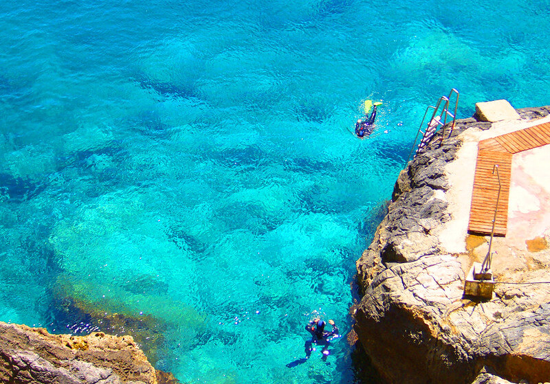 Zwei Taucher genießen die klare Sicht im hellblauen Wasser vor der Küste von Kreta.
