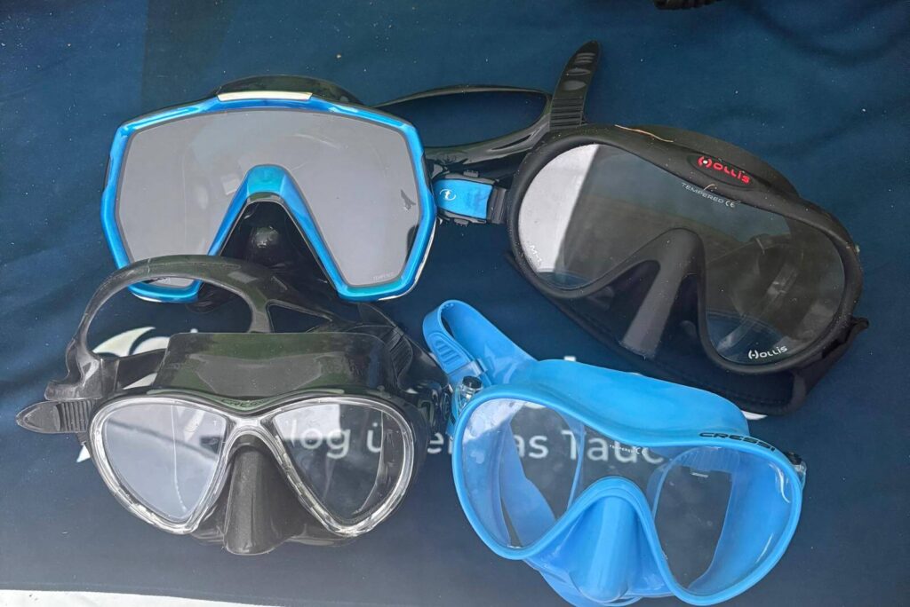 4 Tauchmasken (Cressi F1, Cressi Big Eyes Evo, Hollis M1, TUSA Freedom HD) liegen zum vergleichen nebeneinander