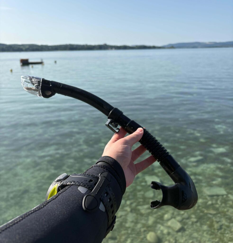 TUSA Hyperdry Elite II Schnorchel wird vor einem See in der Hand gehalten