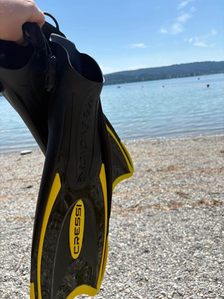 Cressi Palau Schnorchelflossen zum Testen voreinem See in der Hand gehalten