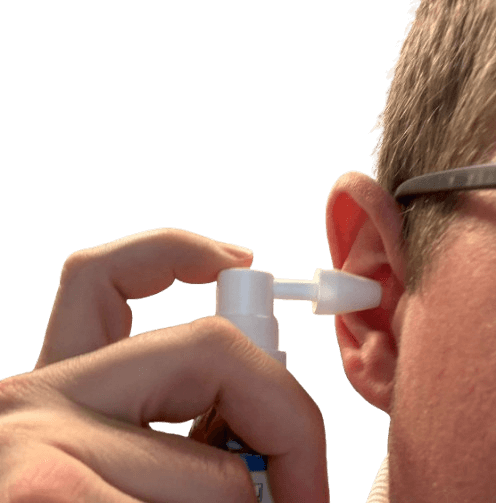 Taucher sprüht Ohrenspray ins Ohr nach dem Tauchen zur Vorbeugung von Entzündungen.