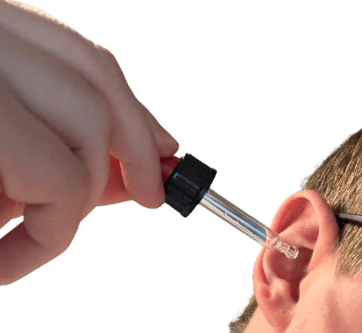 Taucher bringt Ohrentropfen mit Pipette ins Ohr ein, um eingedrungenes Wasser zu entfernen.