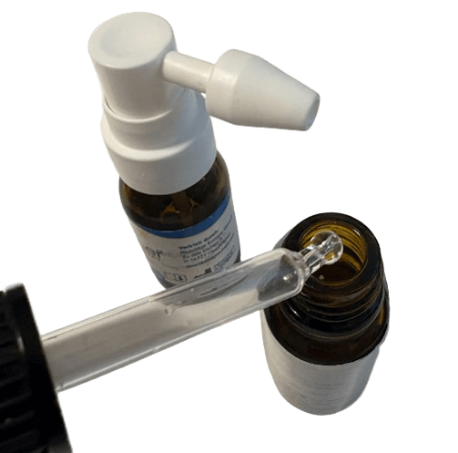 Pipette mit Taucherohrentropfen liegt neben Ohrenspray als Vergleich von Tropfen und Spray.