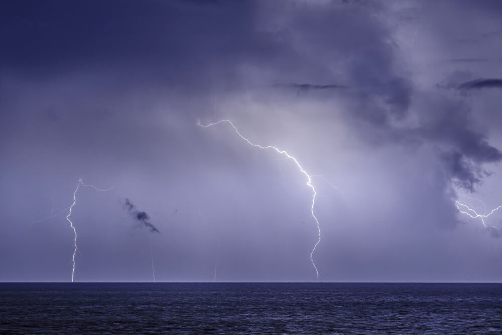 Blitze bei Gewitter schlagen in Waseroberfläche ein