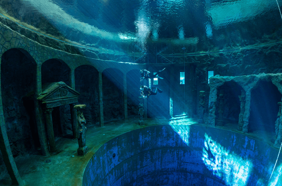 Dive 4 Life Unterwasseraufnahme mit 2 Tauchern vor einer Plattform mit Säulen