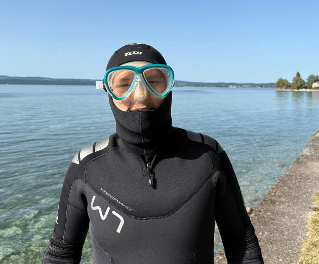 Taucher testet die Passform der TUSA Intega Tauchmaske am Seeufer des Bodensee
