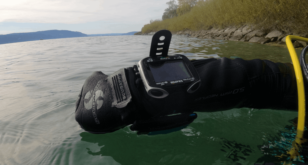 Tauchcomputer am Arm eines Tauchers an der Wasseroberfläche