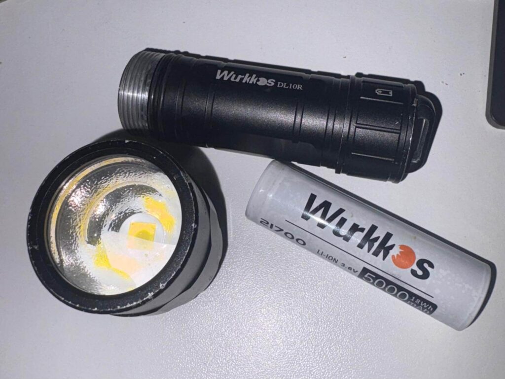 Wurkkos DL10R Tauchlampe mit herausgenommenem 21700 Lithium-Ionen-Akku für den sicheren Transport im Flugzeug.