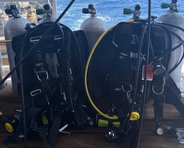 Zwei an Tauchflaschenmontierte Backplate Wing Reisejackets auf einem Boot