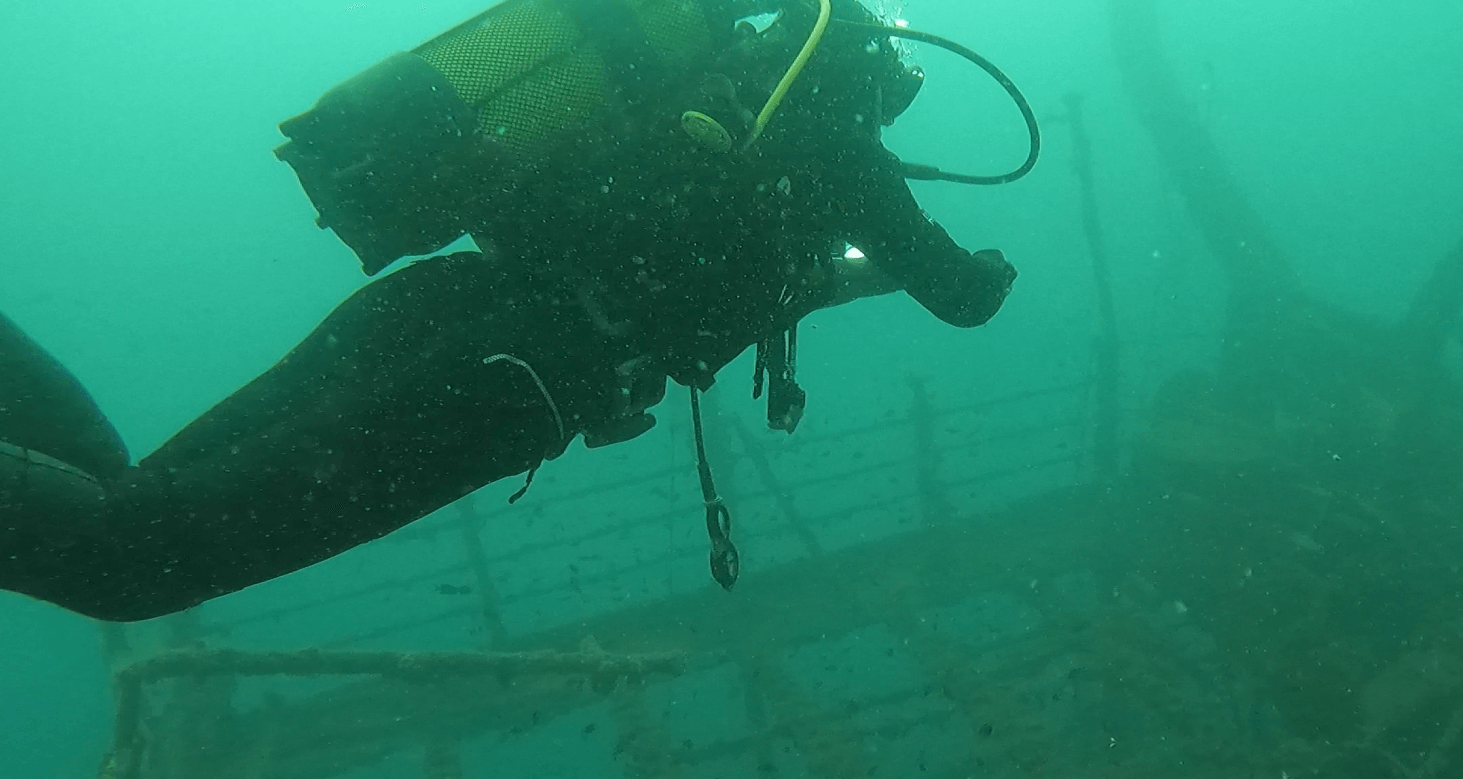 Taucher testet Reisejacket über einem Wrack