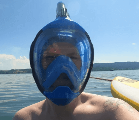 Schnorchler trägt blaue Vollgesichtsschnorchelmaske