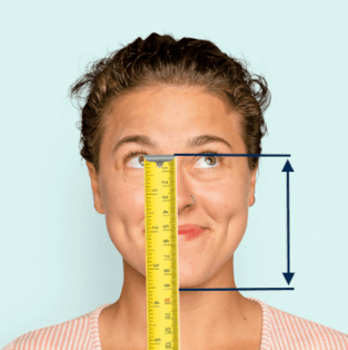 Gesicht einer Frau mit Maßband von Nasenwurzel bis Kinn und eingezeichneten Strichen 