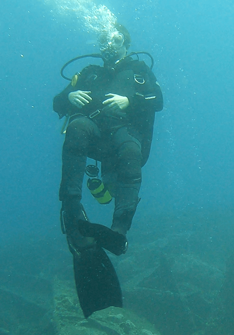 Taucher steht aufrecht im Wasser mit vollausgestatteter Ausrüstung
