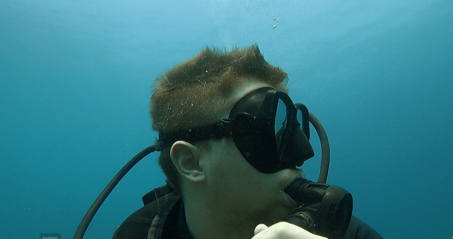 seitliche aufnahme eines tauchers mit oberlippenbart der eine schwarze tauchmaske für bartträger trägt