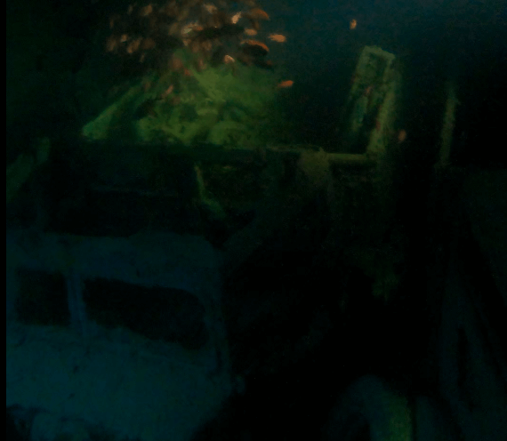 Fischschwarm über alten LKWs