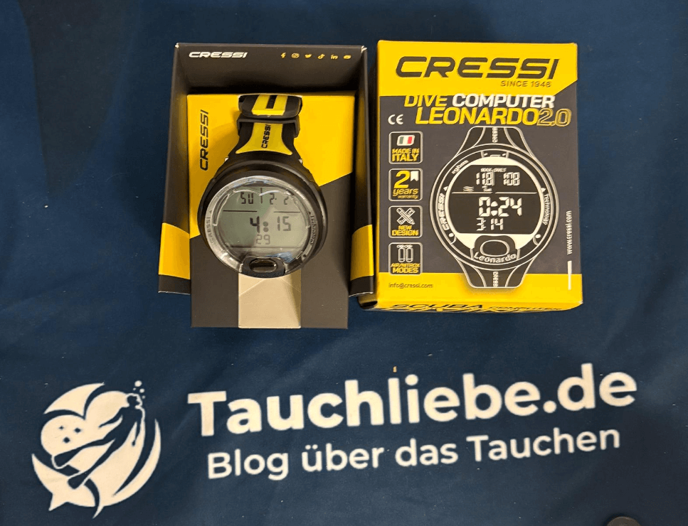 Cressi Leonardo Tauchcomputer liegt neben seiner Verpackugn auf dem Tauchliebe.de Handtuch