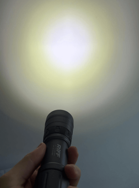 Graue Riff Tauchlampe wird in der Hand gehalten und gegen eine Wand geleuchtet