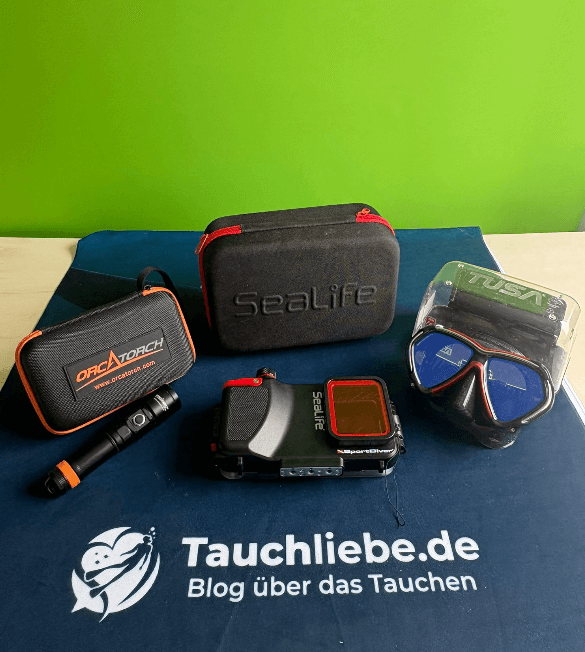 Tauchmaske, Tauchlampe, Unterwassergehäuse liegen im Teststudio auf Tauchliebe.de Matte mit Greenscreen im Hintergrund