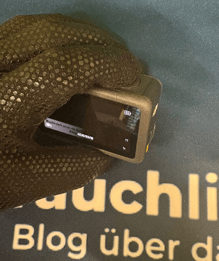 Neoprenhandschuh hält Actionkamera in der Hand