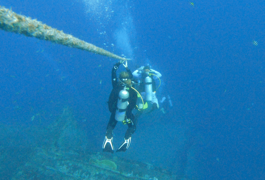 Taucher steigen an Strömungsleine trotz Seekrankheit ab und beginnen den Tauchgang