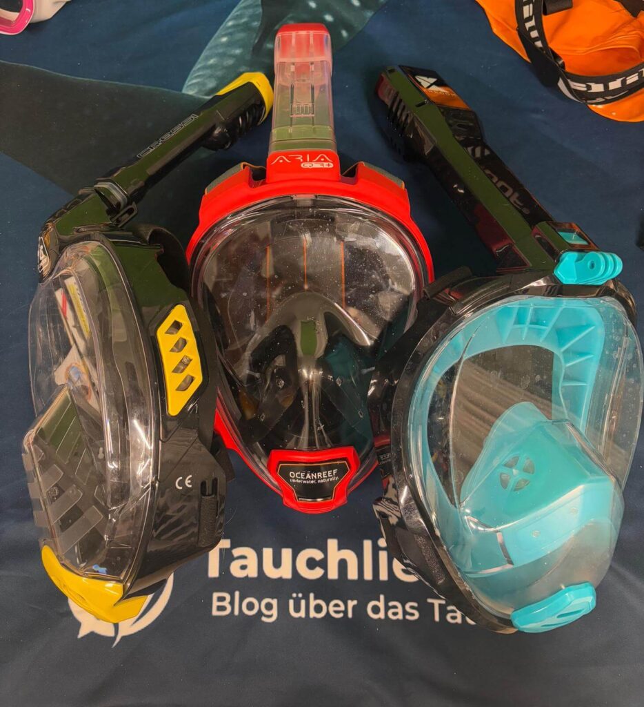 Rote Area Reef QR+ Schnorchelmaske liegt neben Khroom Seaview Pro und Cressi Bali