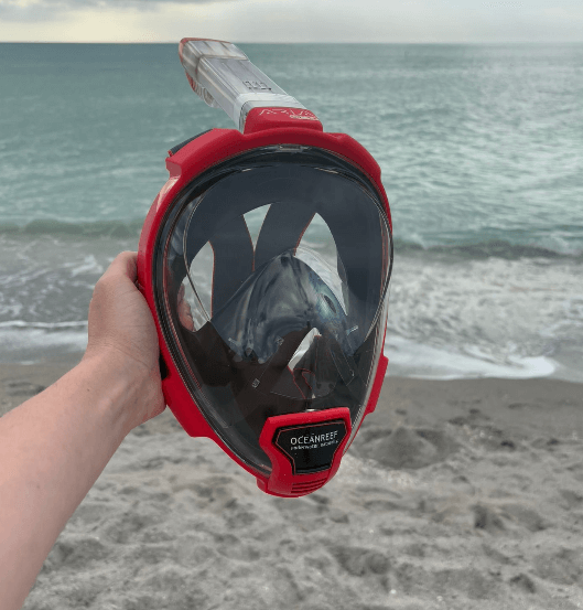 Area Reef QR+ Schnrochelmaske vor Meer am Strand in Hand gehalten