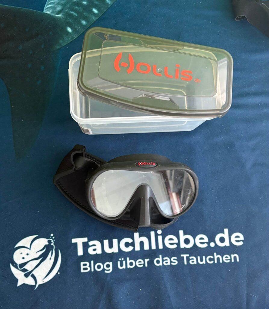 Schawrze Tauchmaske von Hollis liegt auf Tauchliebe Handtuch