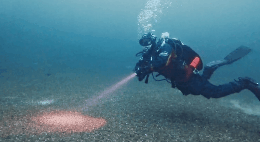 Taucher testet Tauchlampe im See