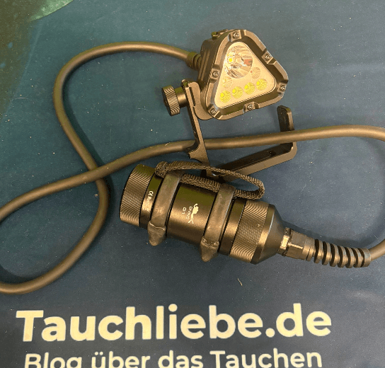 Wurkkos D1 Tauchlampe liegt für den Test mit Canister und Verbindungskabel auf Tauchliebe.de Handtuch