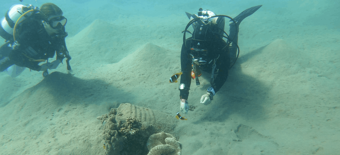 Taucherin trägt unter Wasser eine kompakte Tauchmaske für schmale und kleine Gesichter